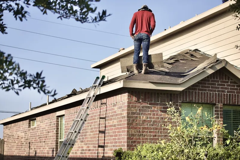 Professional roofer working on a residential roof in Baxter Neck